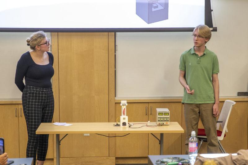 Female and male student present automatic toothpaste dispenser